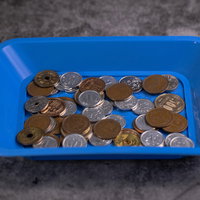 会計トレイに積み重ねられた小銭の山の写真