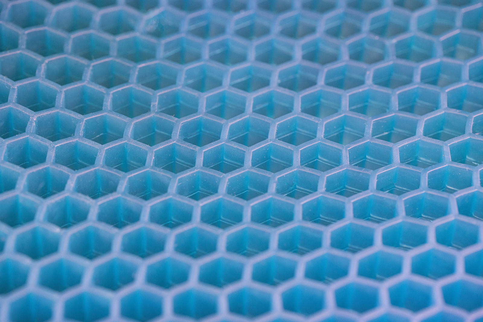 A three-dimensional pattern of regularly arranged blue hexagonal shapes, resembling a honeycomb structure.