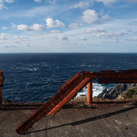 神津島の海沿いで塩害により錆びてへし折れて危険なガードレールの写真