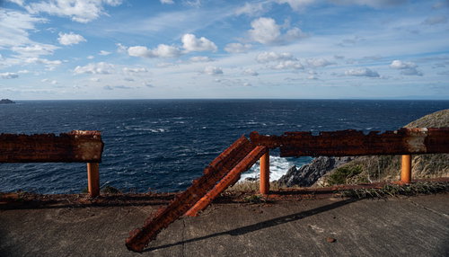 神津島の海沿いで塩害により錆びてへし折れて危険なガードレール