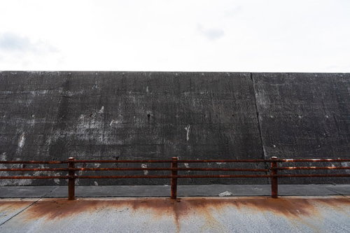 海岸の防波堤に設置された錆び付く金属製の柵