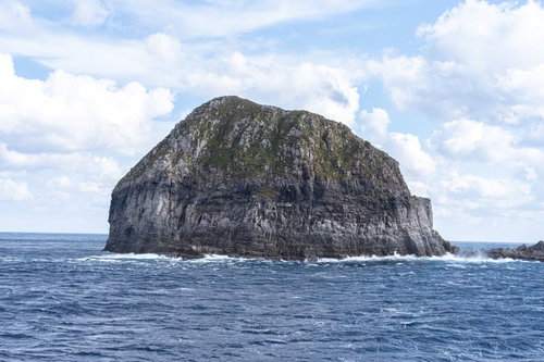 青い海に囲まれた岩山のような孤島の風景