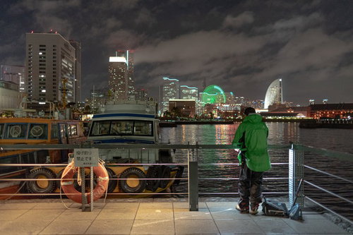 横浜みなとみらいの夜景を背景に夜釣りする人の後ろ姿