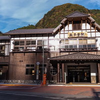 山々に囲まれた奥多摩駅のJR東日本駅舎と駅前広場の写真