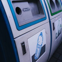 青色投入口のペットボトル用分別ゴミ箱が複数並ぶリサイクルステーションの写真