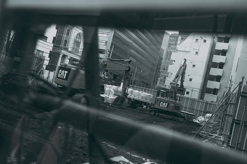 モノクロで撮影した工事現場とショベルカーなどの建設機械