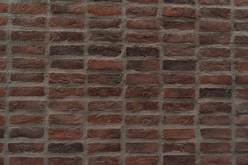 表面に凹凸のある赤茶色のレンガ壁のテクスチャー