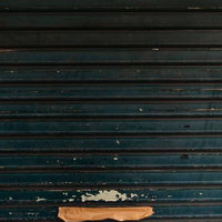 茶色いガムテープが貼られたガレージのシャッターの写真