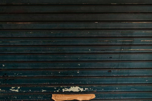 茶色いガムテープが貼られたガレージのシャッター