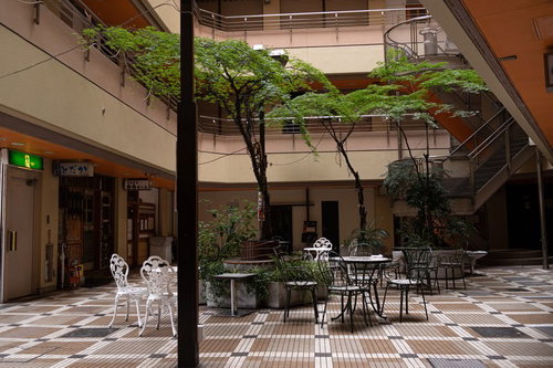 五反田ヒルズの中庭テラスに配置された木製テーブルとチェア