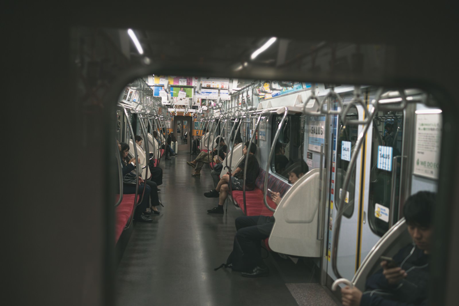 電車の車内で座席に座る乗客たち