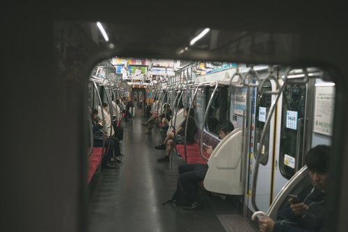 電車の端の座席に座る乗客