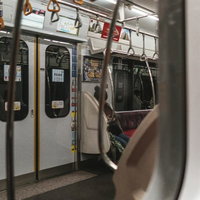 電車のドア付近の車内風景 つり革と手すりのある乗客スペースの写真