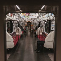 隣の車両から見たガラガラな電車の車両内の様子の写真