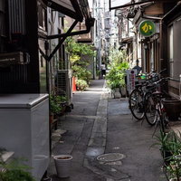 月島の路地裏に立ち並ぶ古い建物と自転車が停められた下町風景の写真