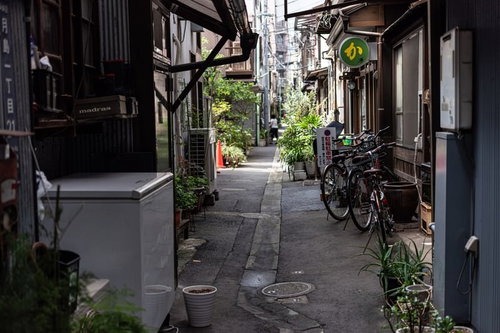 月島の路地裏に立ち並ぶ古い建物と自転車が停められた下町風景