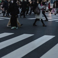 交差点の横断歩道を行き交う通行人たちの足元の写真