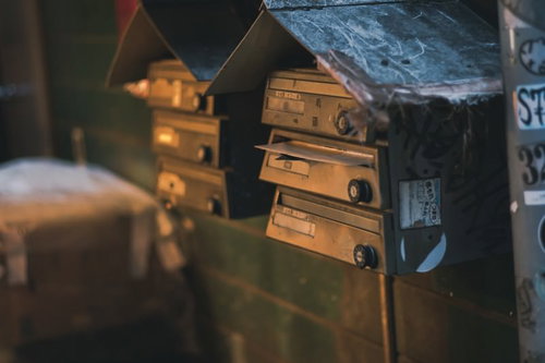 古びて落書きされた郵便受けが並ぶ街角の風景