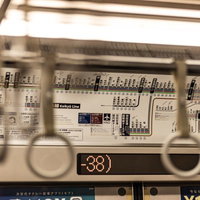 つり革越しに見る京急電鉄の路線図と車内風景の写真