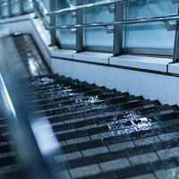雨粒が付着した歩道橋の階段と濡れた手すりの写真