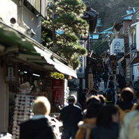 観光客であふれる江ノ島弁財天仲見世通りの坂道商店街の写真