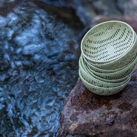 銭洗弁財天の水洗い後のおわん型ザルに積まれた硬貨の写真