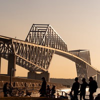 夕暮れ時の東京ゲートブリッジと人のシルエットの写真