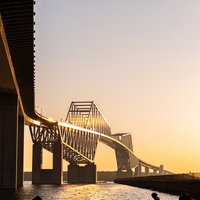 夕焼けに染まる東京ゲートブリッジのシルエットの写真
