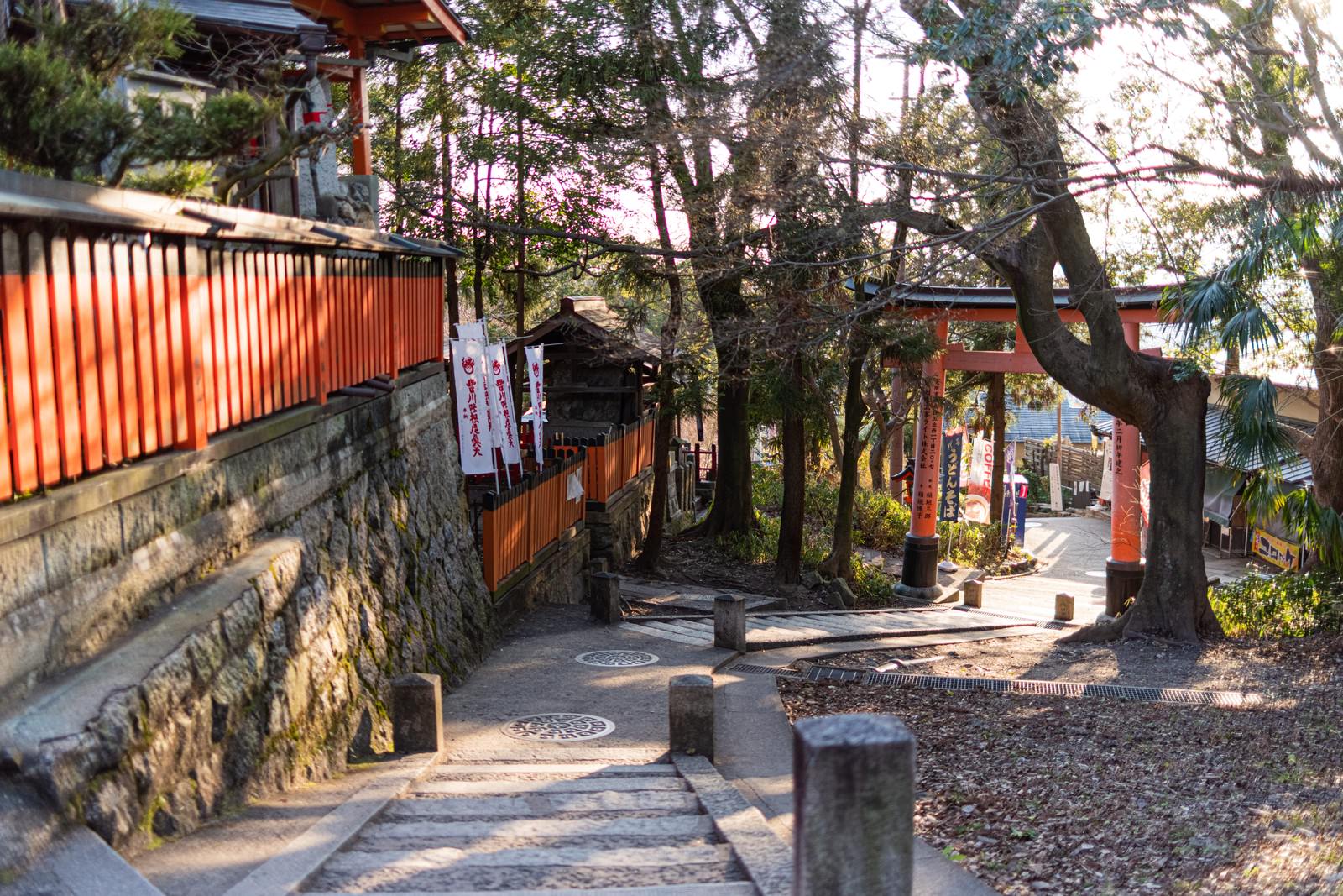 伏見稲荷の足利稲荷大明神横にある朱色の鳥居と石垣に囲まれた下り階段