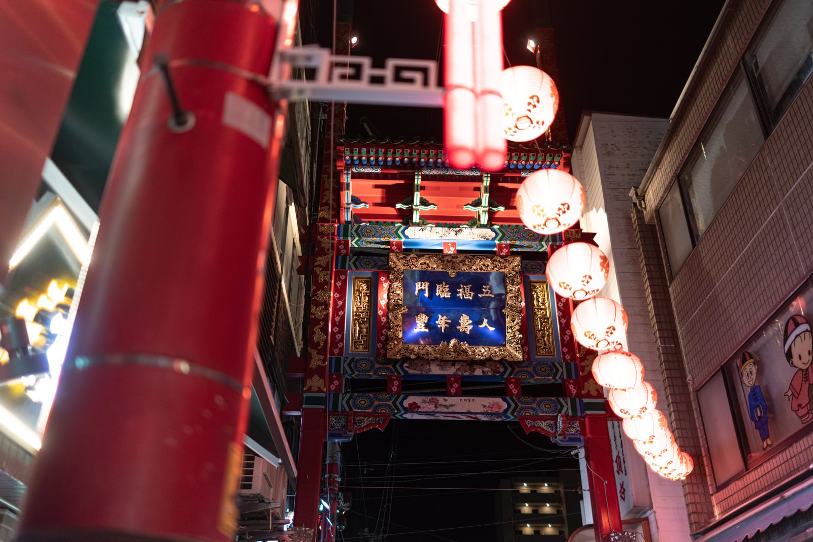 赤い提灯が複数吊り下がる夜の横浜中華街で台南小路の看板が見える路地裏の風景