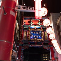 赤い提灯越しに見る台南小路の看板と夜の中華街の風景の写真