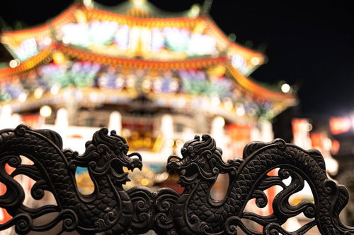 龍の装飾越しに見た横浜中華街の夜景、色鮮やかにライトアップされた建物