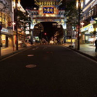 夜の横浜中華街、朱色にライトアップされた朝陽門の写真