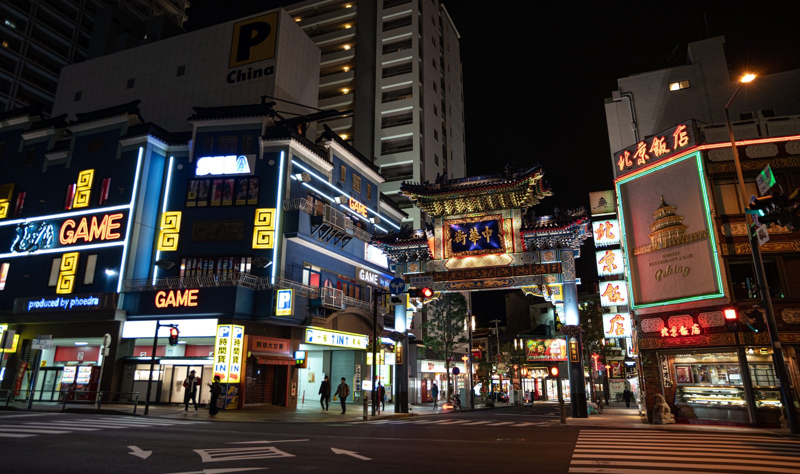 夜にライトアップされた横浜中華街の朝陽門と色とりどりのネオンサイン