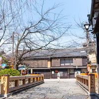 京都祇園の石畳に架かる木造の巽橋と伝統町家の景観の写真