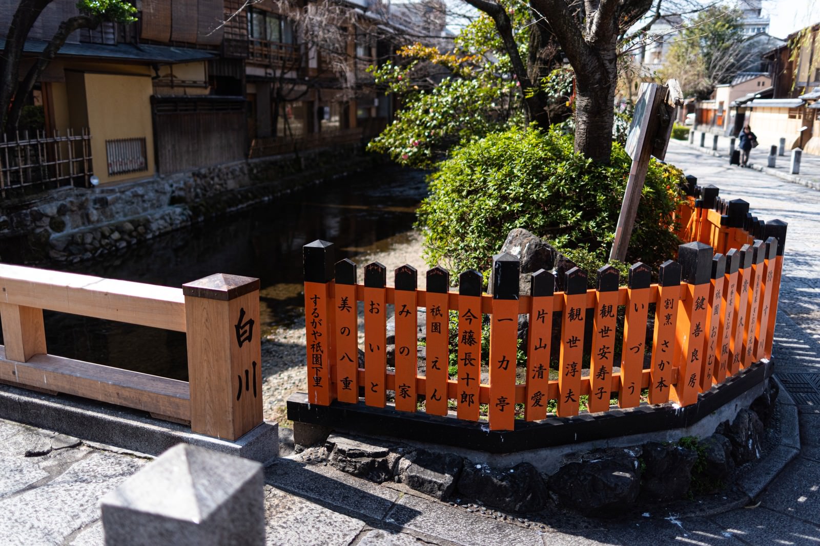 祇園の石畳の道と白川沿いに設置された茶色い木製の柵