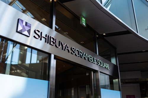 渋谷スクランブルスクエアのガラス張り建物に設置された白い看板