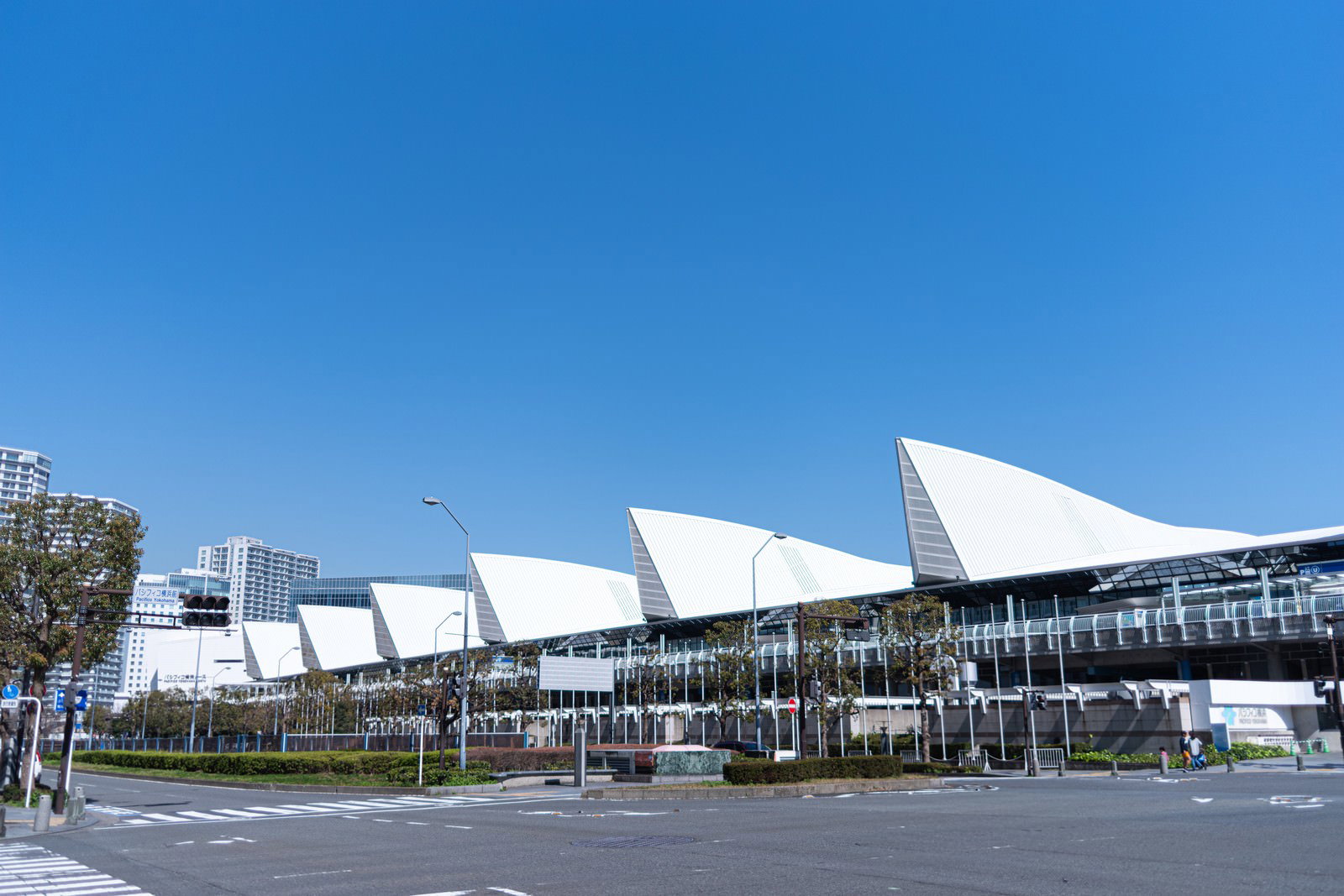 青空の下に白い三角屋根が連続するパシフィコ横浜展示ホール