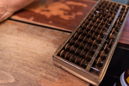 長年使い込まれた木製の算盤 - 伝統的な計算道具