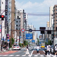 横断歩道を渡る人々と都市の街並みの写真