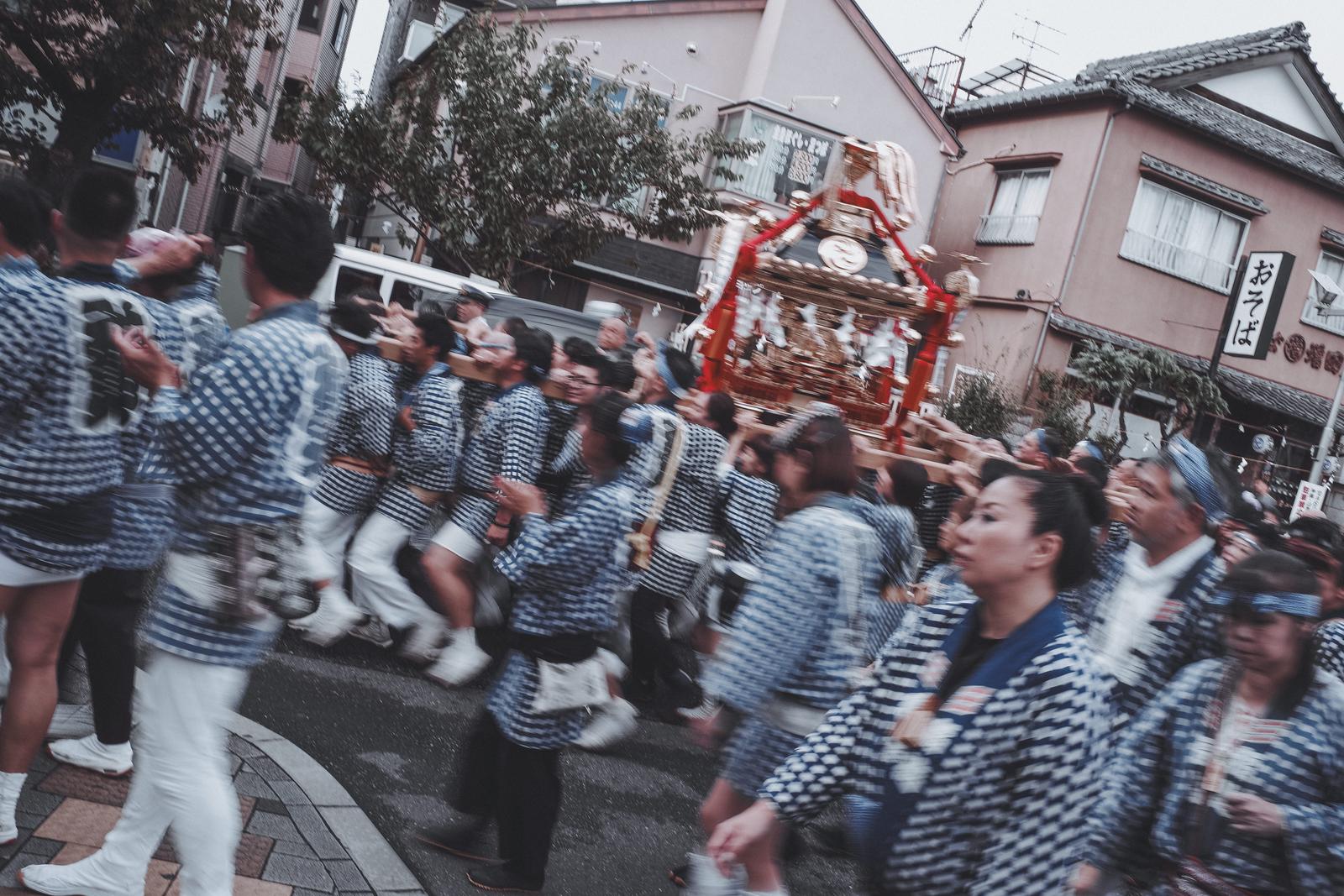 お神輿を担いで街を走る祭りの担ぎ手たち