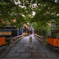 京都・祇園白川の古橋、石畳の路地に立つ巽橋の写真