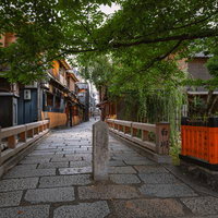 京都祇園・白川の古橋と石畳に並ぶ町家風景の写真