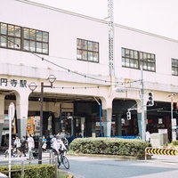 JR高円寺駅前の駅舎と周辺の町並みと人通りの写真