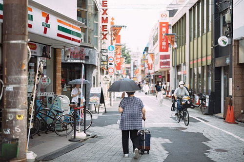 雨の日の高円寺北の純情商店街を歩く傘姿の人々