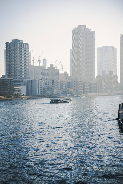 霞の中に見える都市の港、海に浮かぶ船とビル群