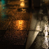 雨の夜の石畳と水たまりの写真