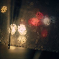 雨の日のパラソルに映る街灯と車のテールライトの写真