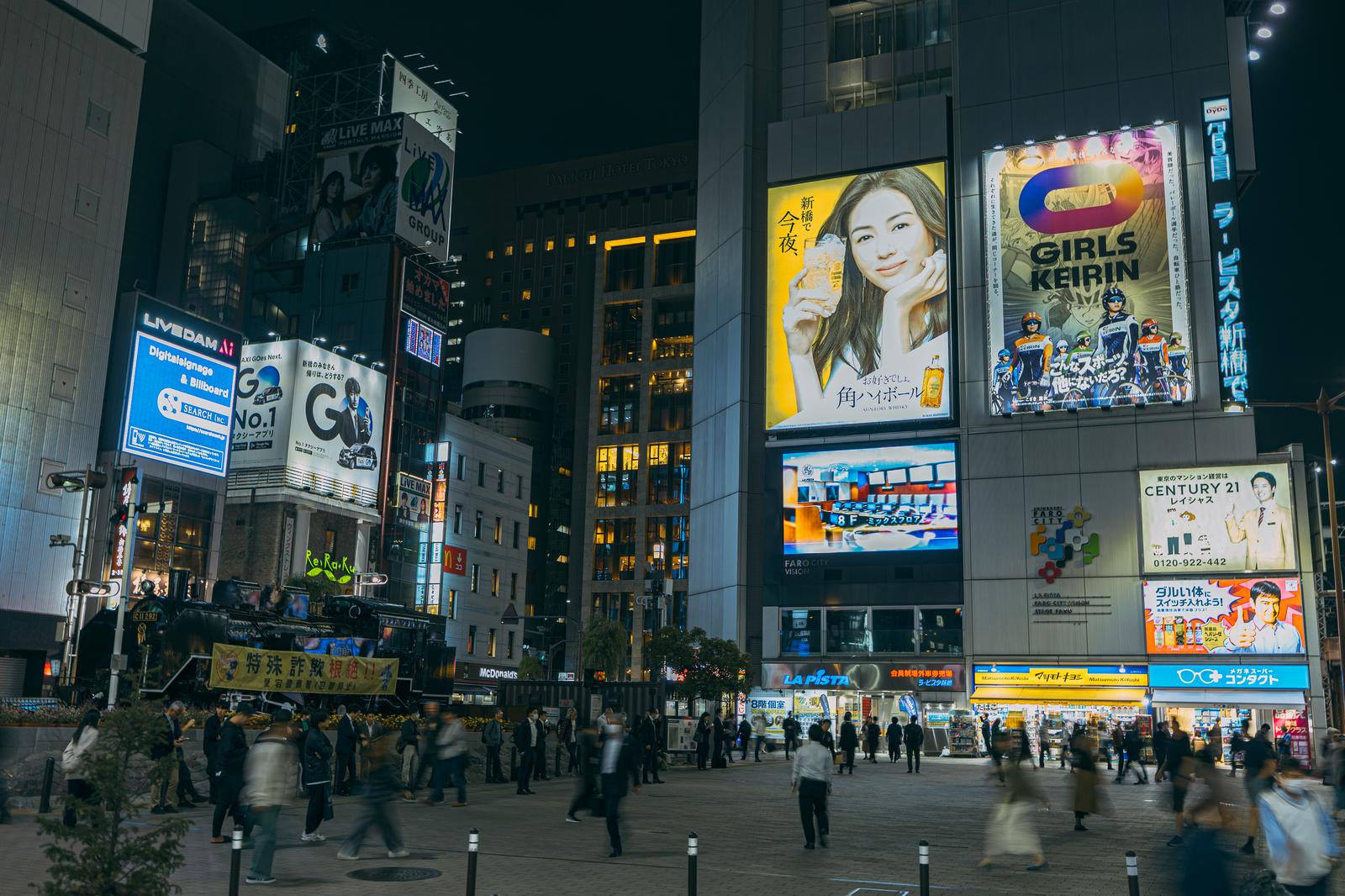 新橋SL広場前で待ち合わせする人々や行き交う会社員の夜間風景