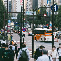 交通量の多い西新宿一丁目の交差点を行き交う人々と車の写真
